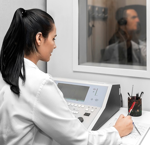 Audiologist recording results from a patients hearing test